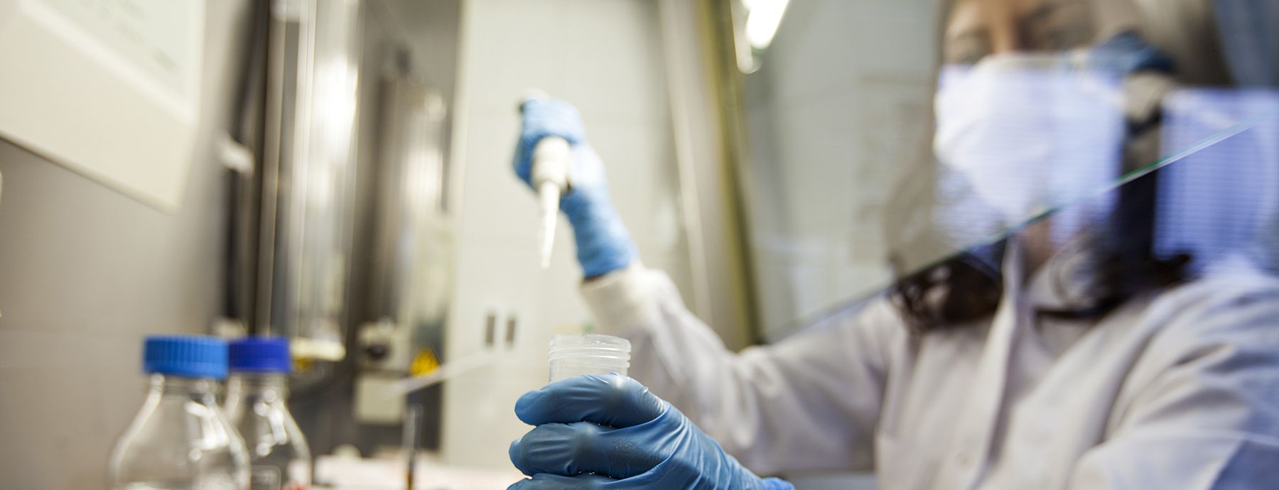 image of a woman filling a test tube