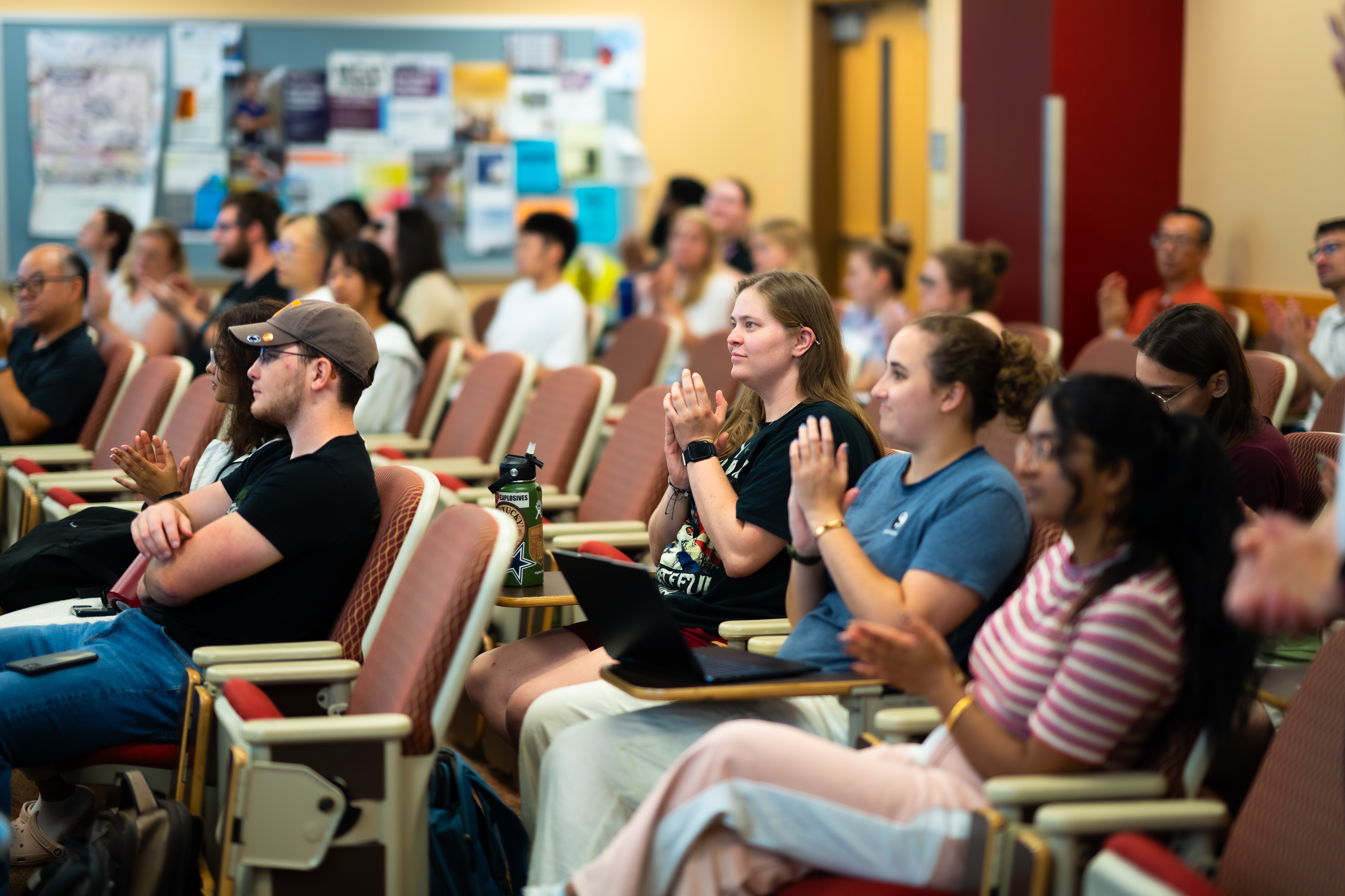 students clapping at a symposium