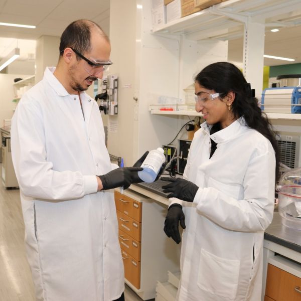 2024 My Green Lab Consultants Zaman Ataie and Ananya Gollakota check the expiration date on a chemical bottle. Credit: Lydia Vandenbergh. All Rights Reserved.